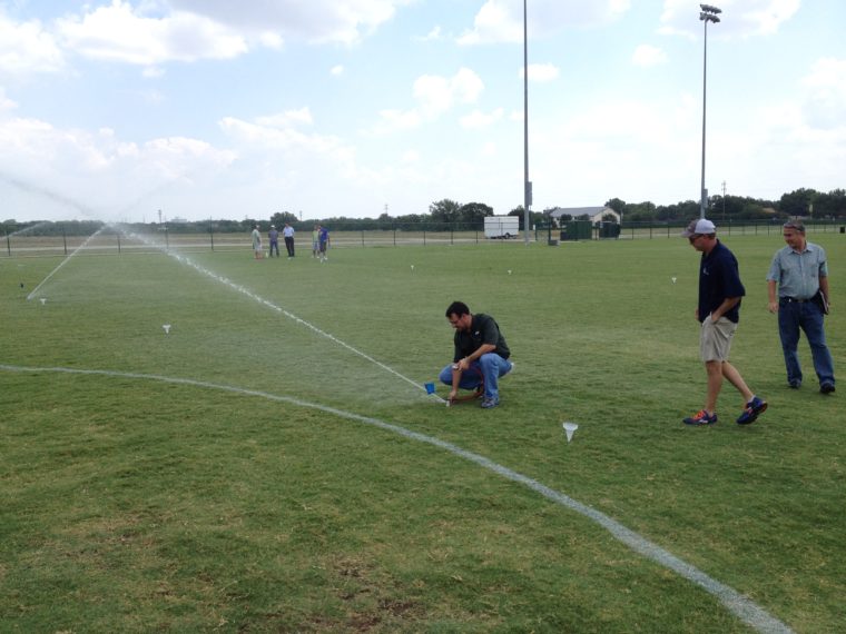 Irrigation students testing their sprinklers and using catch cans to measure application rates.